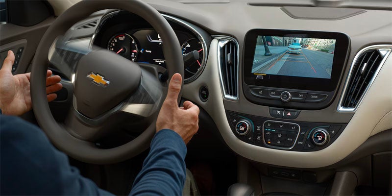 Interior view of Chevy Malibu dashboard and steering wheel, showcasing backup camera